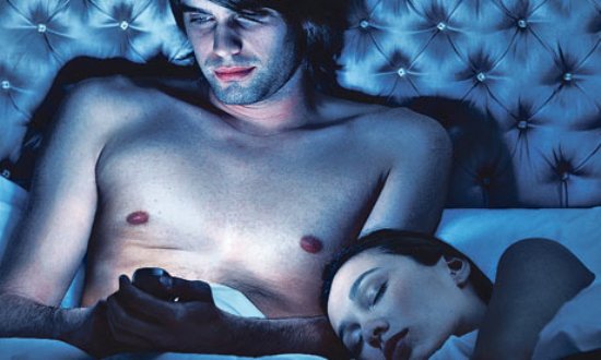 man-using-iphone-in-bed